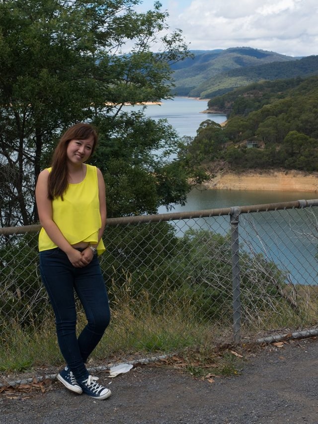 Christina Zhou stands in front of a reservoir.