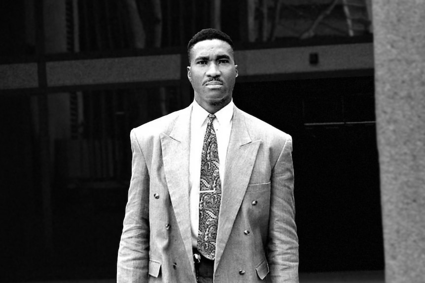 Black and white image of a tall man in a suit