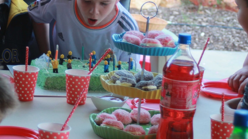 A table laid out for a child's party with a child in the background