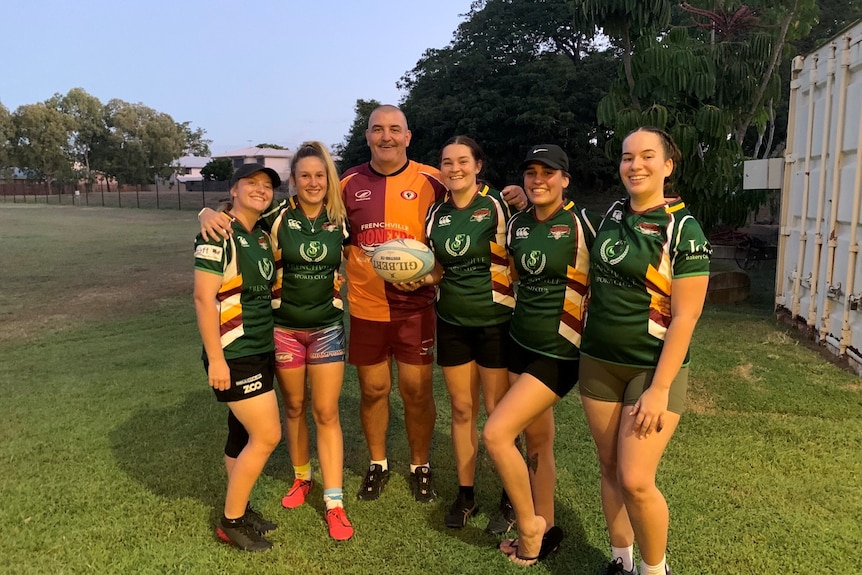 Five women's rugby players standing in a line 