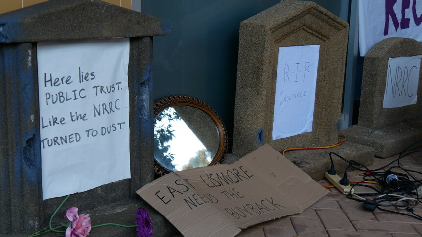 Protestors lay mock tombstones out of frustration over the slow pace of flood recovery. 