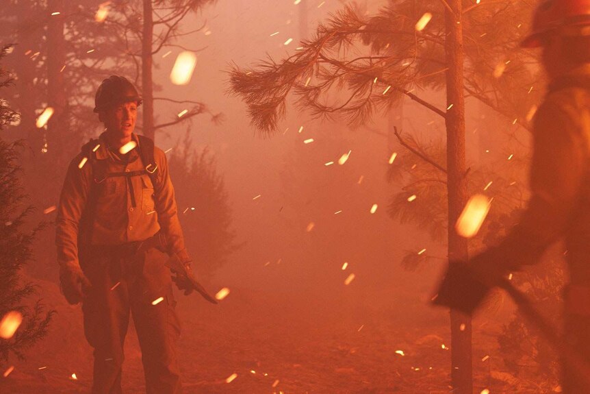 Still image from 2017 film Only The Brave of actors Miles Teller and Taylor Kitsch dressed as firefighters in scrubland.