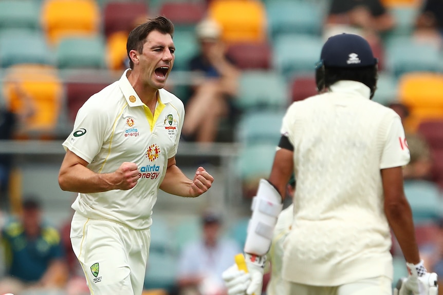 An Australian bowler pumps his fist as he runs close to an English dough in the first men's Ashes Test at Gabba.