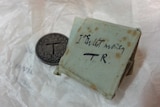 A valuable coin and handwritten note owned by the artist Tom Roberts.