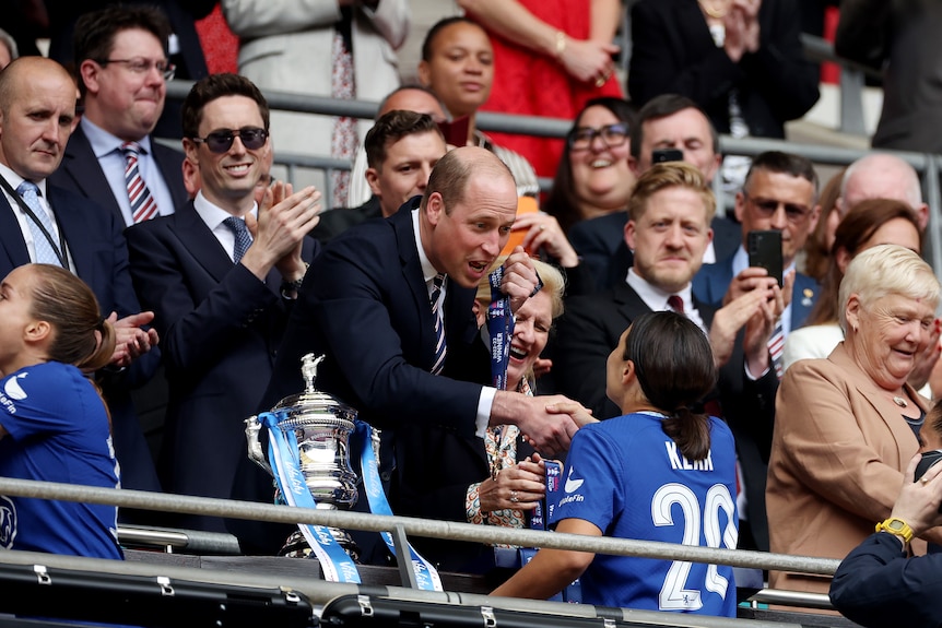Prince William shakes Sam Kerr's hand as he presents her with a medal for winning the Women's FA Cup final.