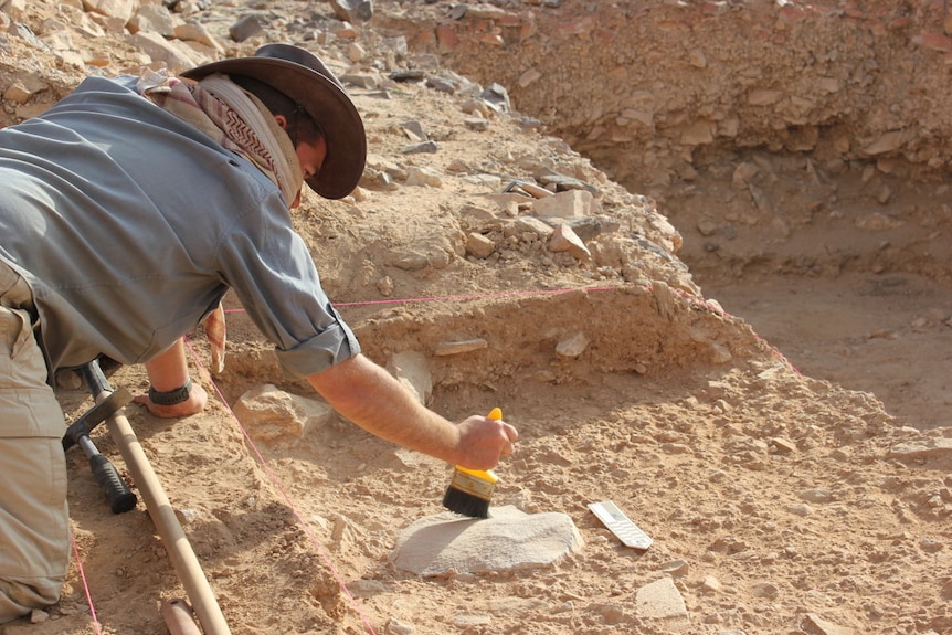 Ceri Shipton uses a brush at an archaeological dig in Saudi Arabia