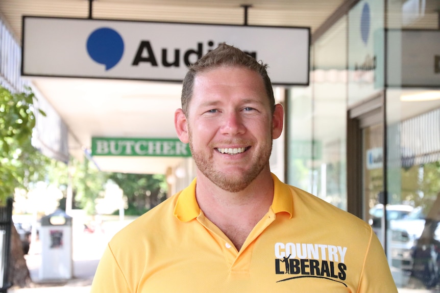 A man wearing a polo shirt with the words 'Country Liberals' on it smiles at the camera.