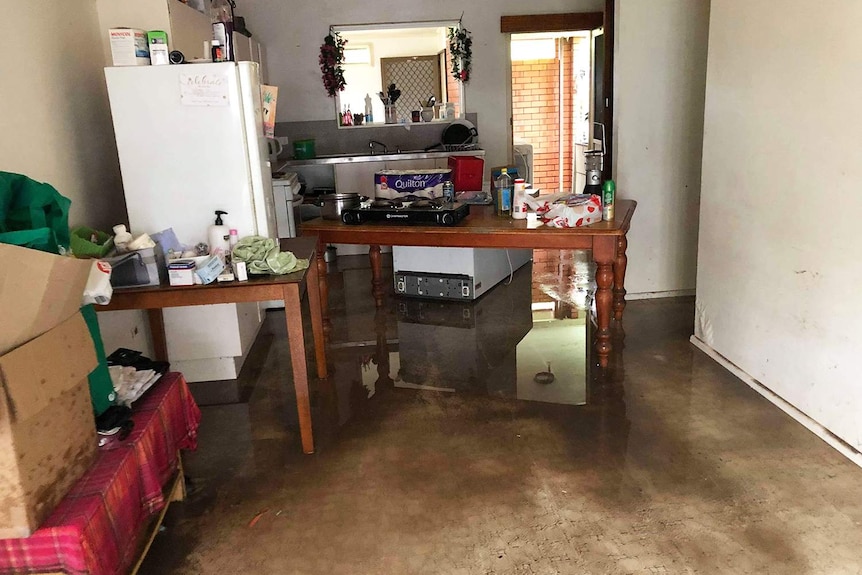 Muddy water on floor of damaged kitchen of Donald Mosby's flood-ravaged home in Mundingburra.