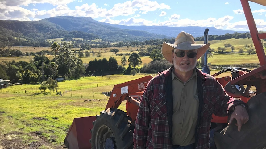 Farmer, Tim Francis standing beside a tractor on farm near Berry.