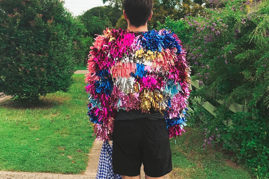 an image of a man wearing a jacket made of multiple colours of tinsel 