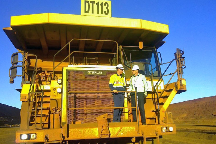 Tony Abbott on the front of a giant yellow mining truck at FMG's, Fortescue Metals Group, Cloudbreak mine in the Pilbara