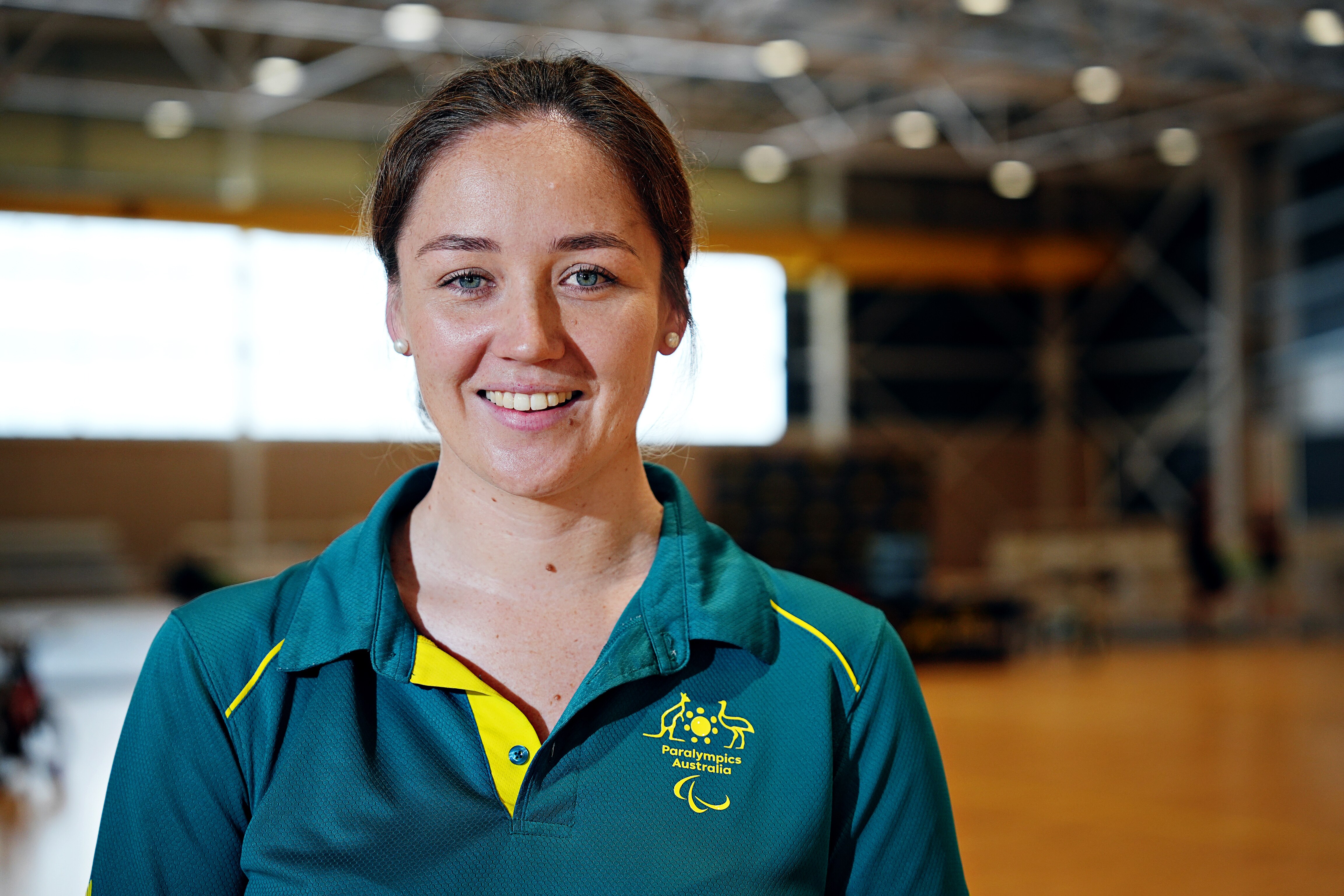 una mujer joven que llevaba una camiseta con cuello dorado y verde 