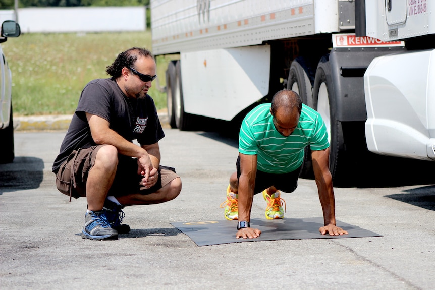 Siphiwe Baleka demonstrates push ups to a fellow truckie