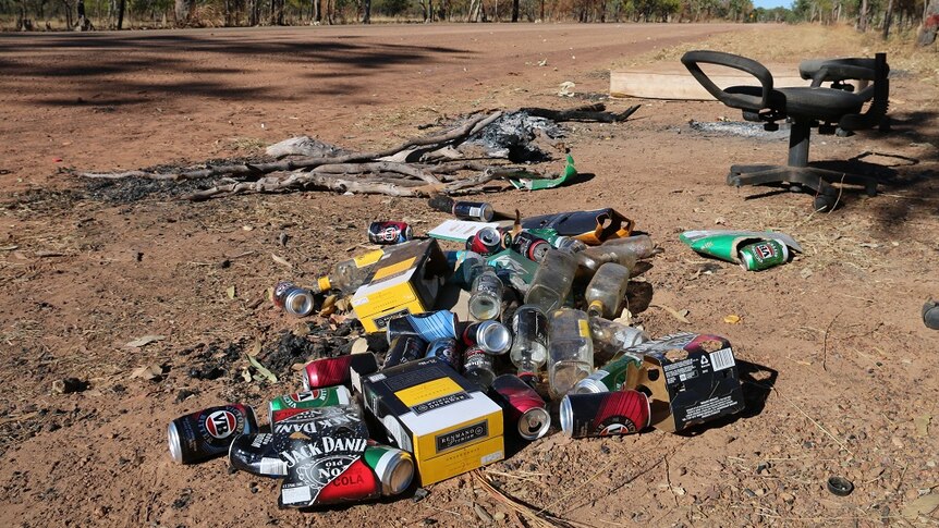 Piles of cask wine boxes and beer cans near a dirt road at Barunga