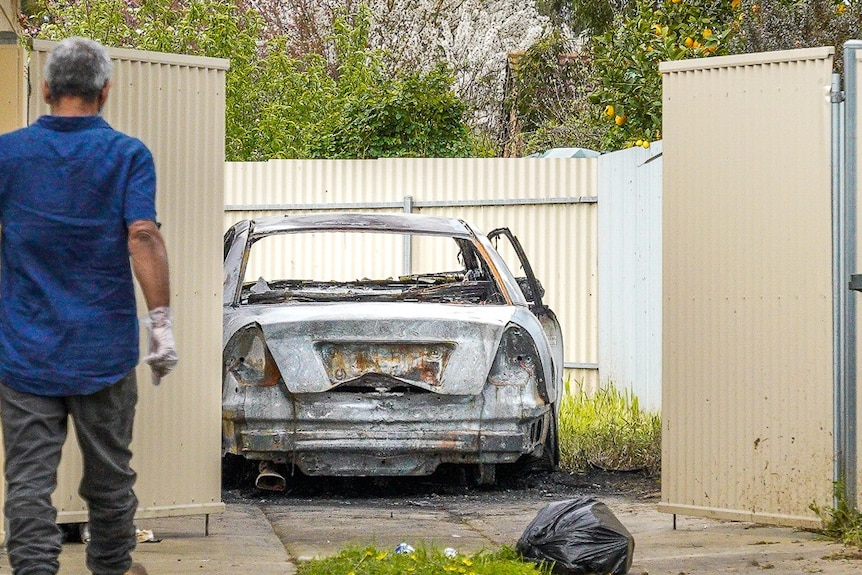 A torched car in the yard of a Mount Gambier home.