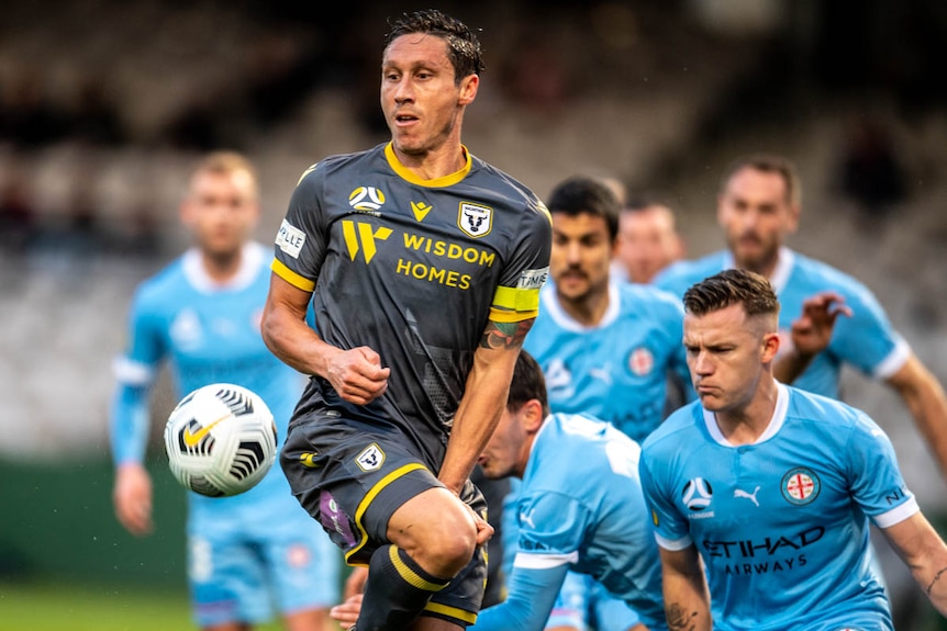 A Macarthur FC A-League player protects himself against the ball.