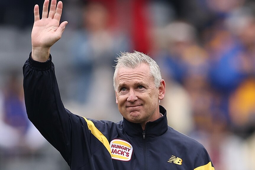 Adam Simpson waves to Eagles fans in the crowd before the game