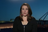 Annika Smethurst sits in a TV studio with parliament house behind her