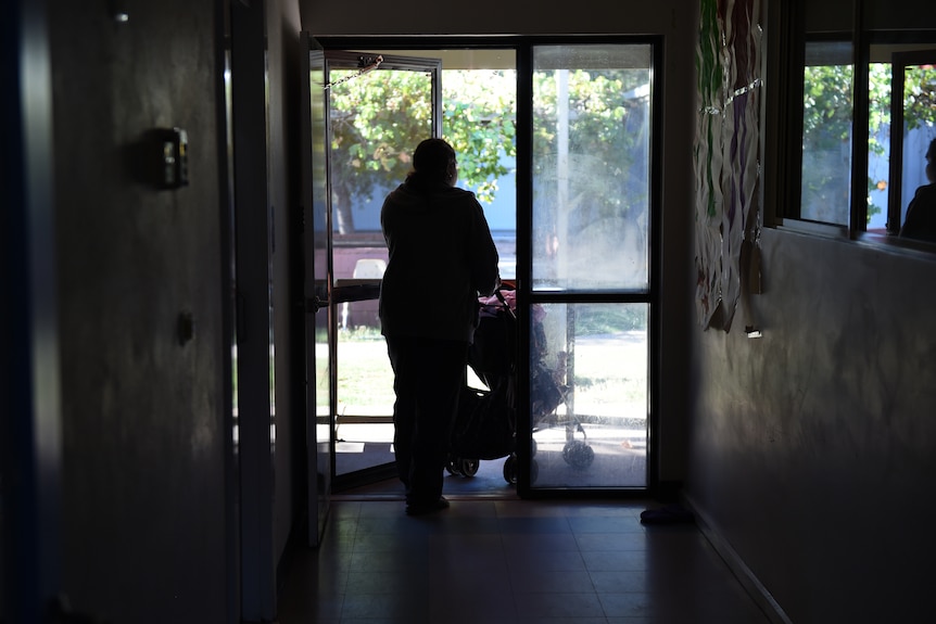 a woman pushing a pram in a hallway