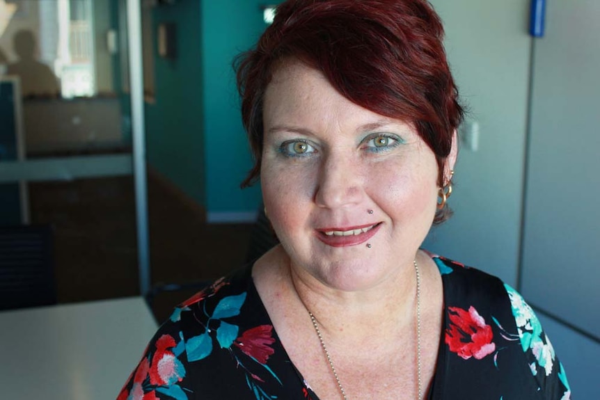 Lady with bright red hair and green eyes smiling in the ABC studio