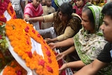 Bangladeshi people lay floral wreaths in memory of the victims of Rana Plaza