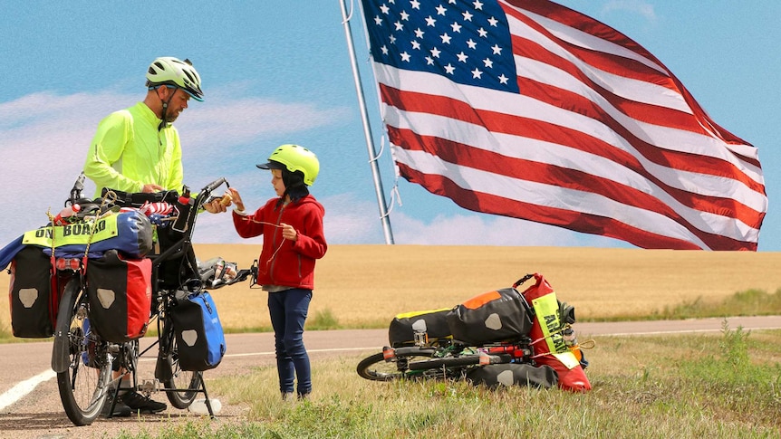 Travis Saunders and his seven-year-old autistic son Patch stand by the side of a sealed road with their bikes.