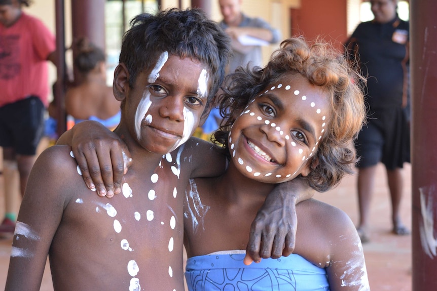 Derby indigenous children with faces painted pose at parade.