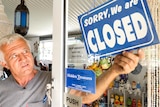 Richard Adams puts a closed sign on his shop doorhas c 'Hidden Treasures' in Mogo