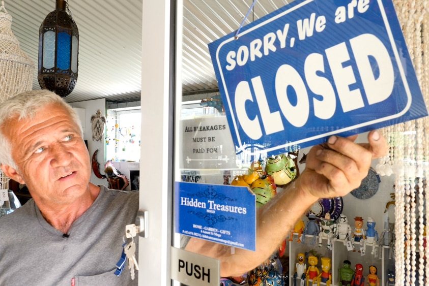 Richard Adams puts a closed sign on his shop doorhas c 'Hidden Treasures' in Mogo