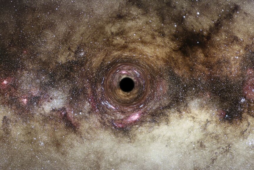 A grey and pink-tinged starfield has a dark black hole at its centre, around which the light from the stars seems to bend.