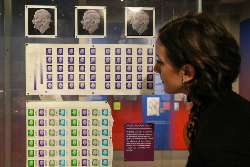 A woman looiks at a series of stamps. 