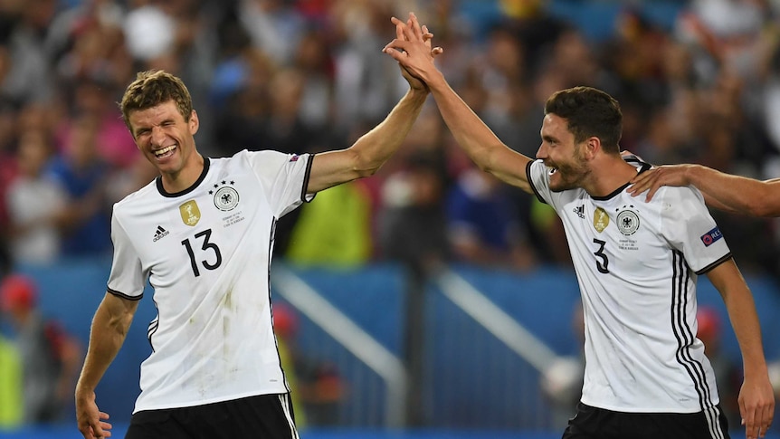 Winners are grinners ... Thomas Mueller (L) and Jonas Hector celebrate Germany's victory