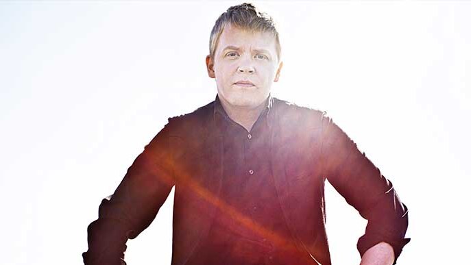 Violinist Pekka Kuusisto looks directly at the camera with hands on hips.