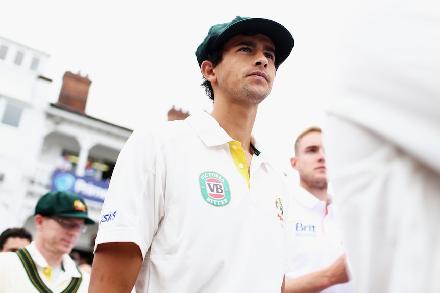 A man in white walks onto a cricket ground