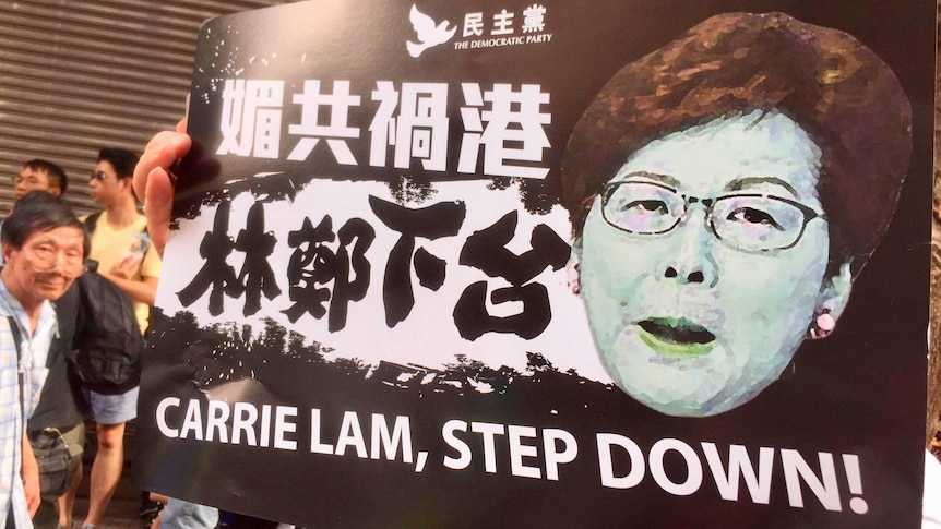 Protesters carry placards calling for Carrie Lam to step down at protests in Hong Kong in June 2019.