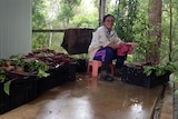 Farmer Som Young sits on a milk crate washing beetroot.