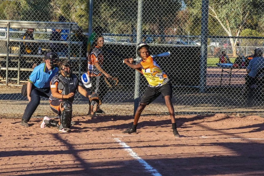 A batter swings at a softball pitch.