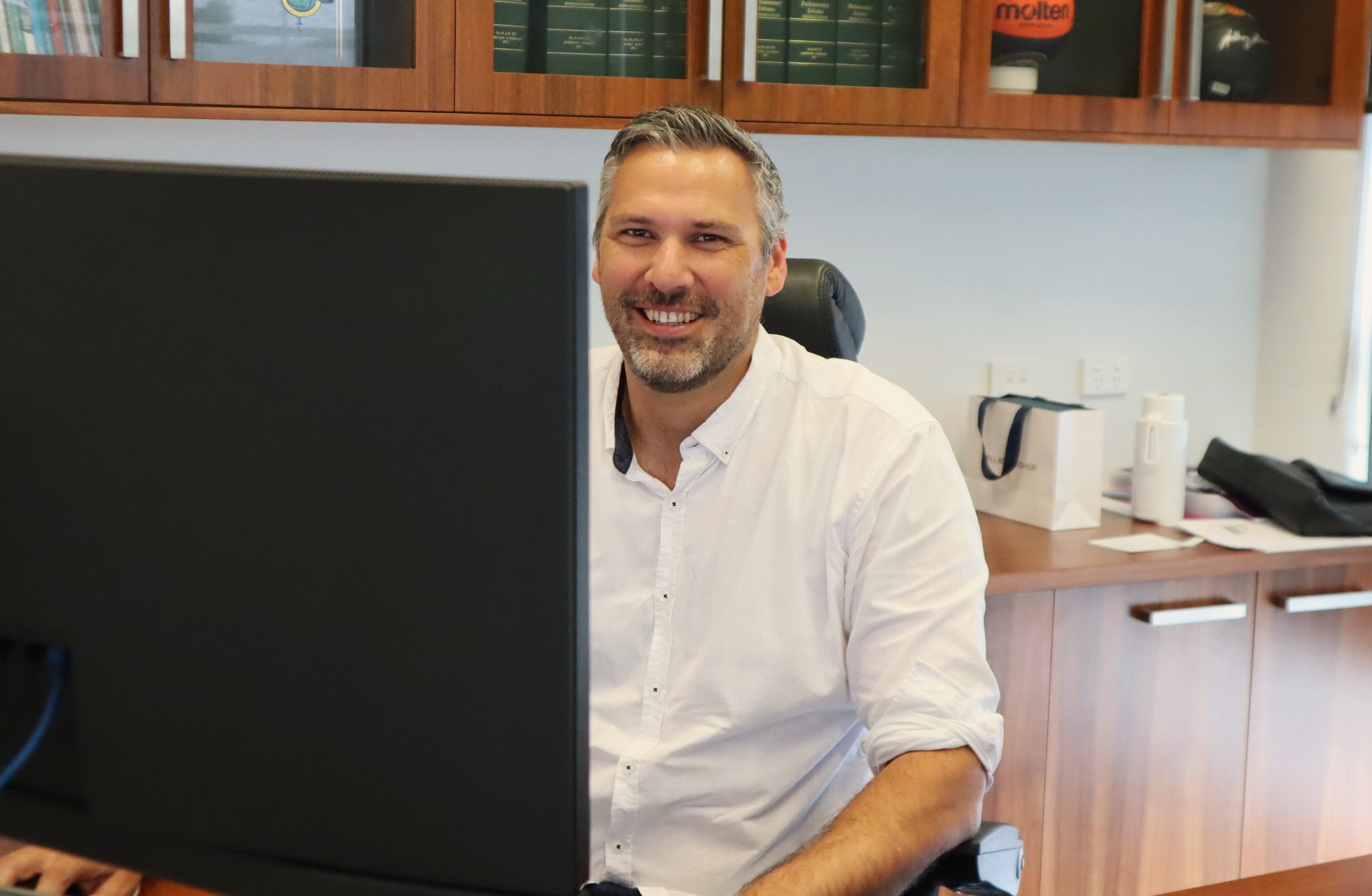 Matt Smith, diputado de Leichardt, sonríe detrás del ordenador.