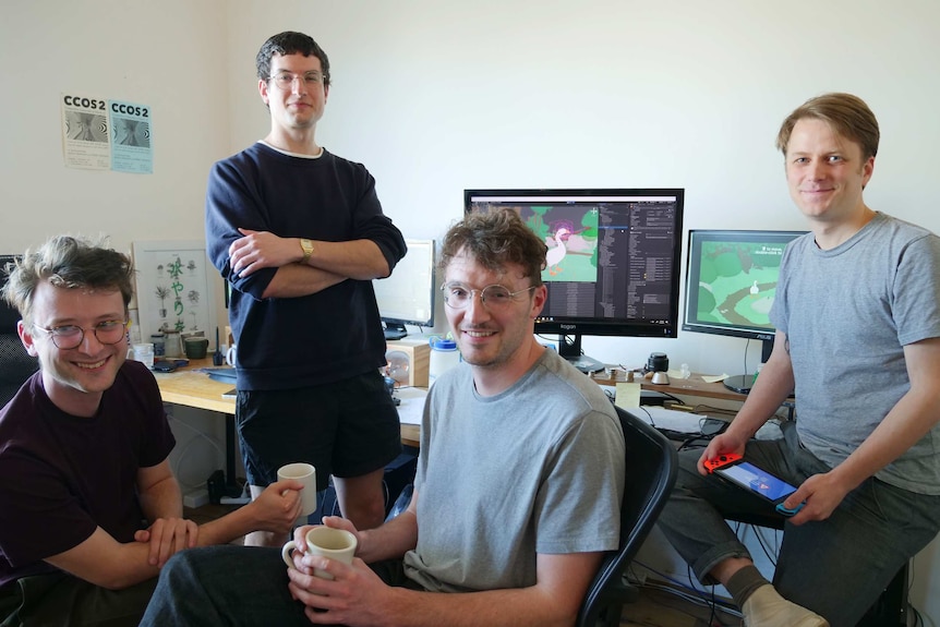 The four game creators pose for a photo in their studio