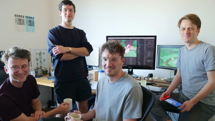 The four game creators pose for a photo in their studio