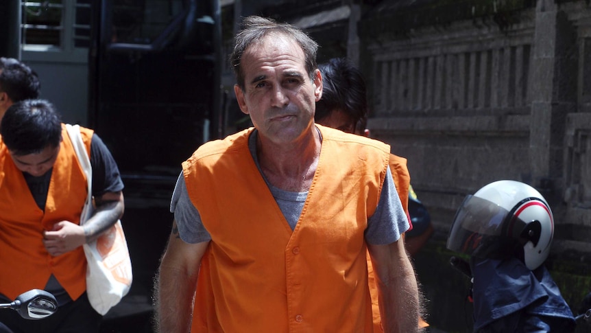 Australian Giuseppe Serafino, wearing prison orange, walks into a Bali court.