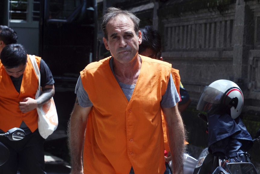 Australian Giuseppe Serafino, wearing prison orange, walks into a Bali court.