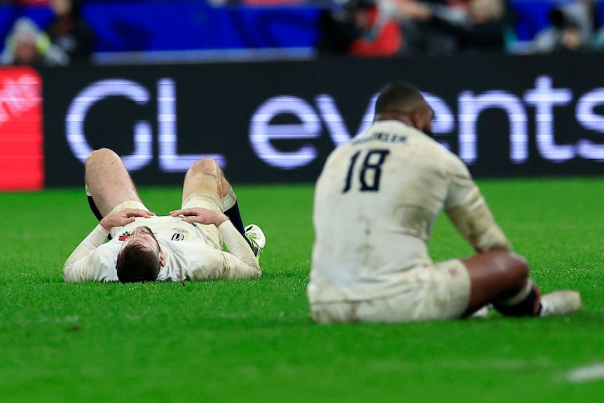 England players lie and sit on the ground