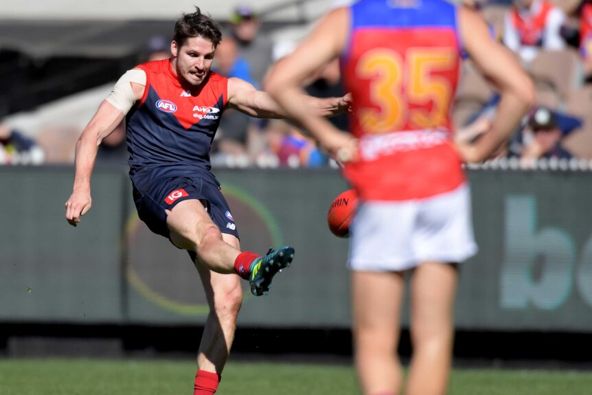Jesse Hogan of the Demons takes a mark and scores a goal against Brisbane.