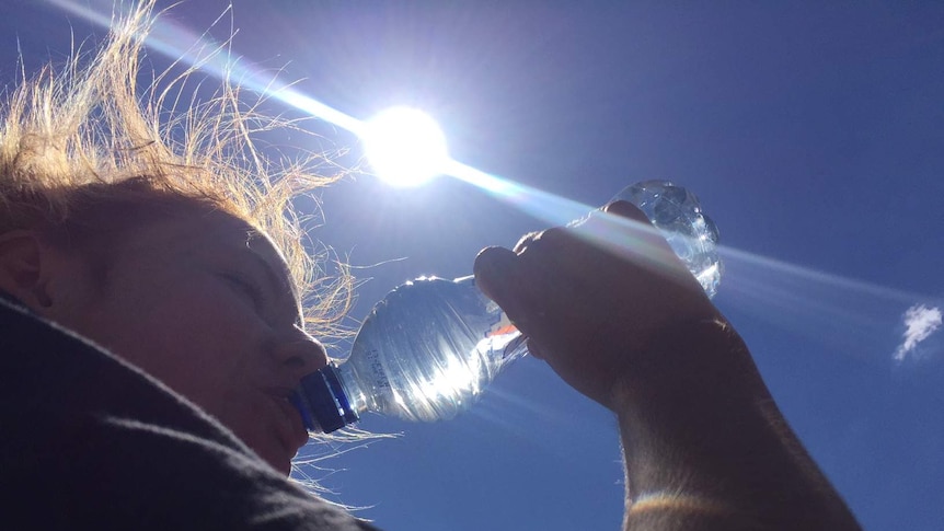 A woman drinks water on a hot day in Canberra