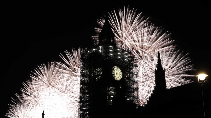 Bright white fireworks explode behind the 'Big Ben' clock tower in London.