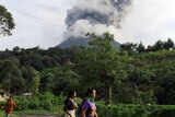 Residents flee the area following the eruption of Sinabung volcano