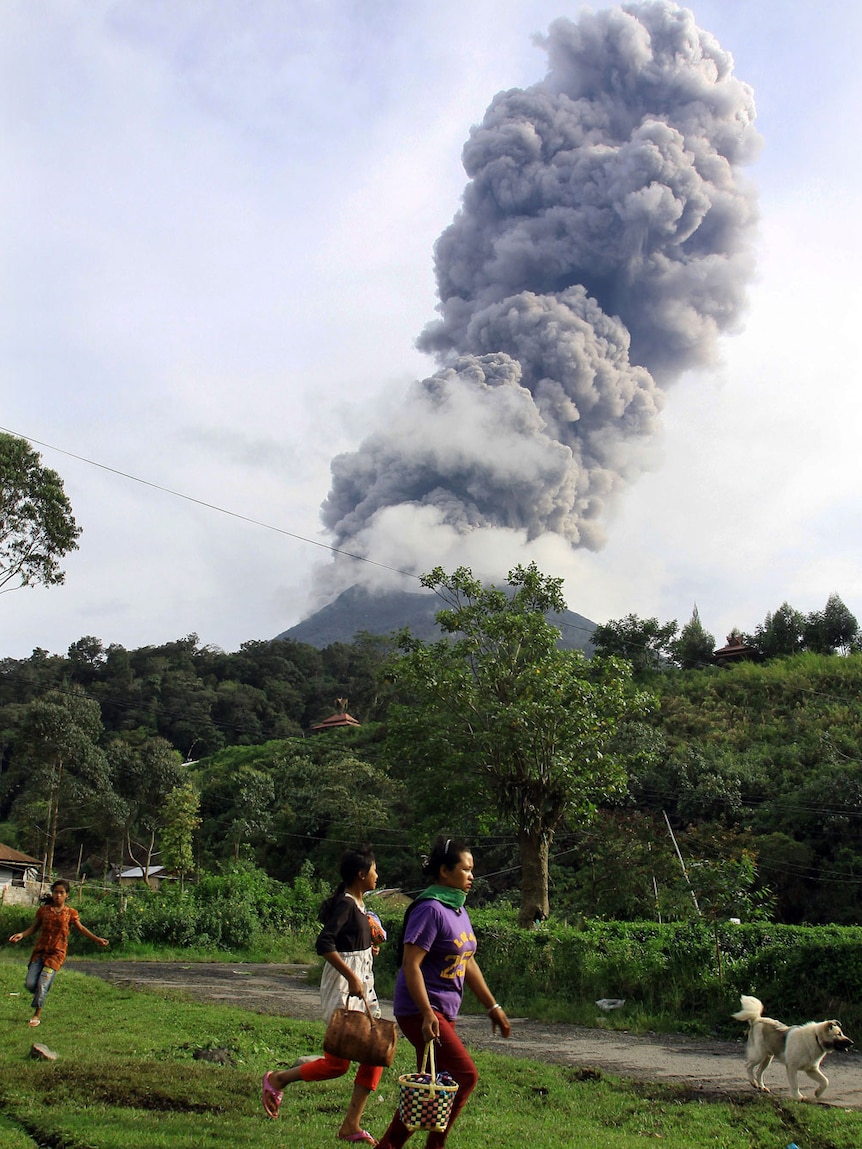 Residents flee the area following the eruption of Sinabung volcano