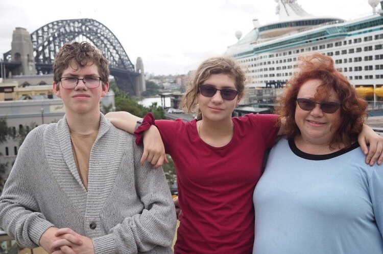 Hamish, Amethyst and Cheryl Westbury standing next to each other in front of Sydney Harbour Bridge