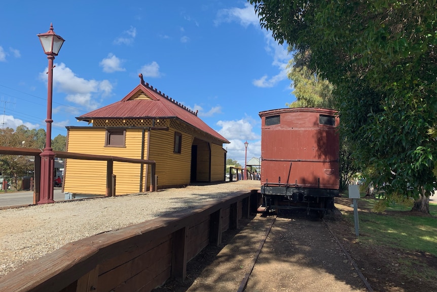 A small wooden train station in Koondrook Township with a replica steam train on what remains of the tracks.